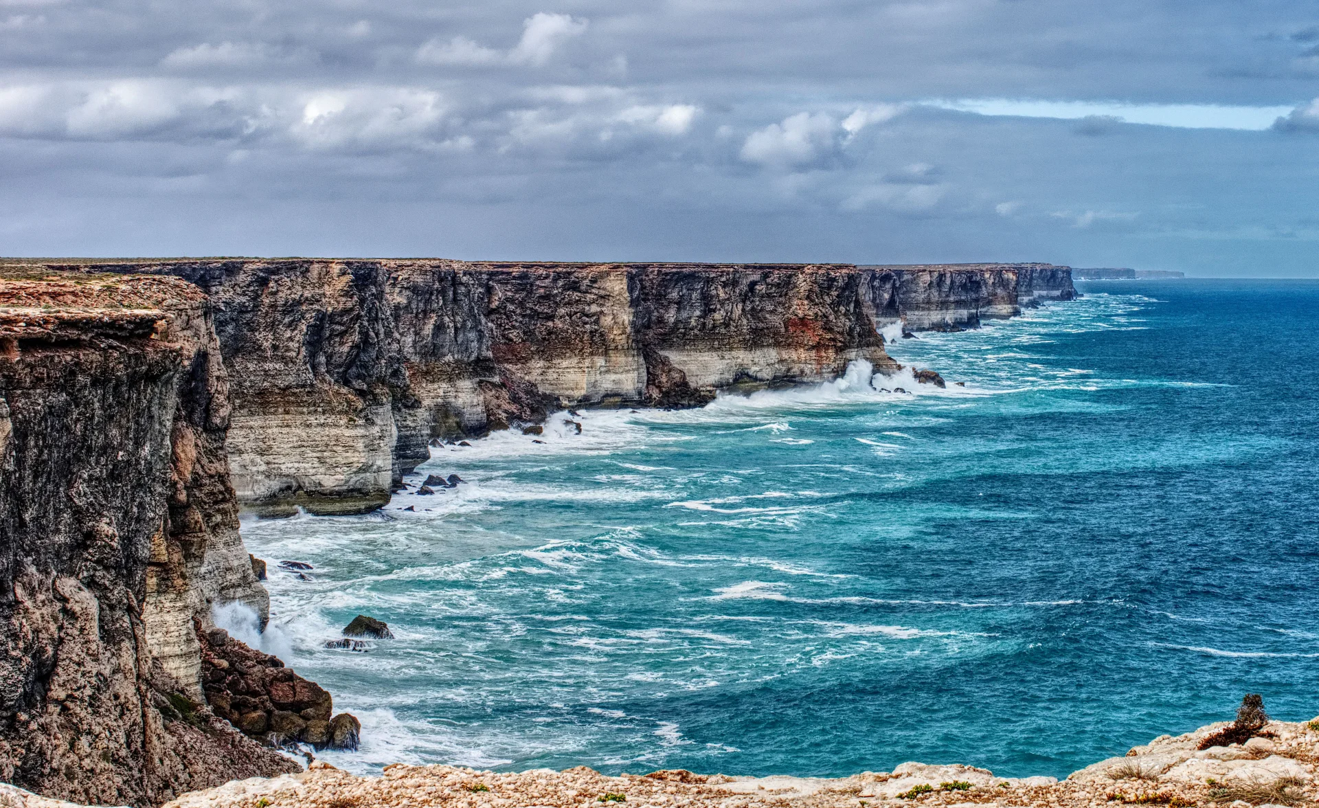 Layered coastal cliffs above bright blue water on the Nullarbor coast.